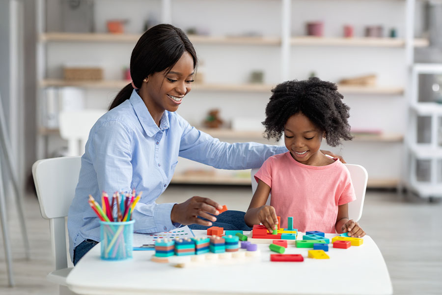 kid and child development specialist playing with bricks at a clinic-based ABA therapy session