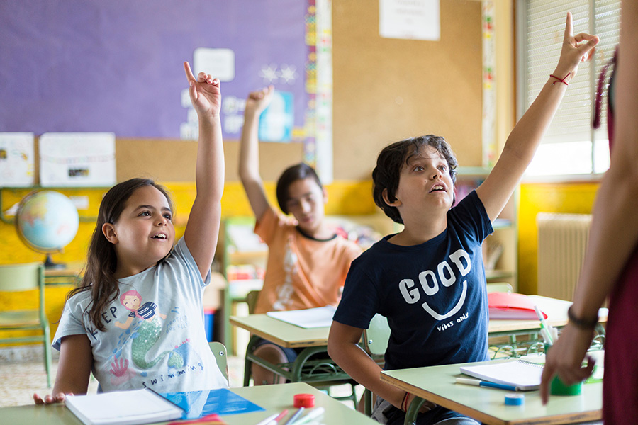 Children in a school-based ABA classroom raising their hands