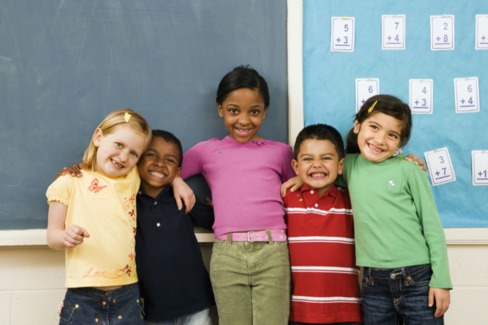 diverse group of young kids smiling and hugging one another at one of BCBH developmental social groups